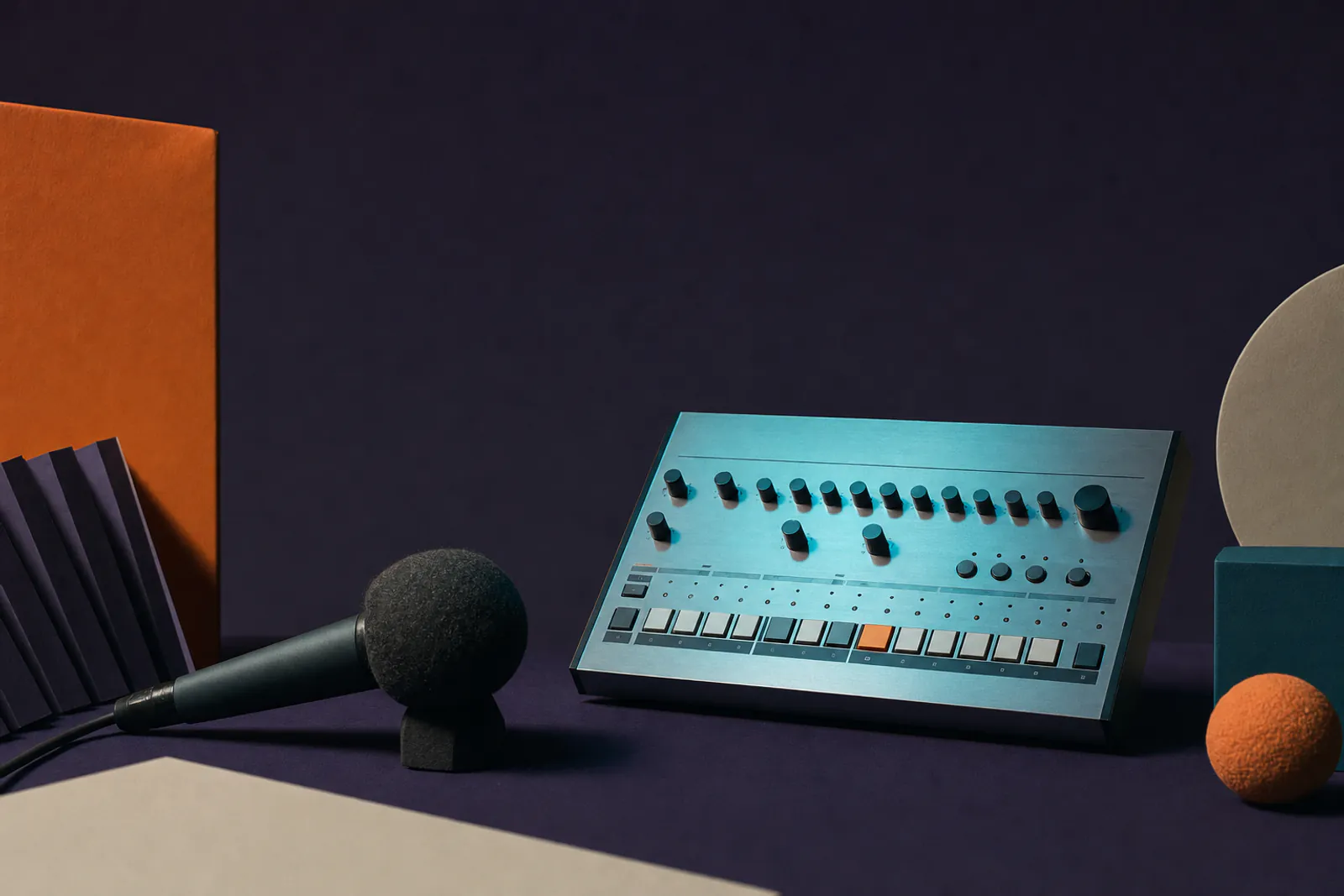 Illustration: a brushed aluminium 808 drum machine and a dark felt microphone under cold teal light on a violet field, one orange accent.